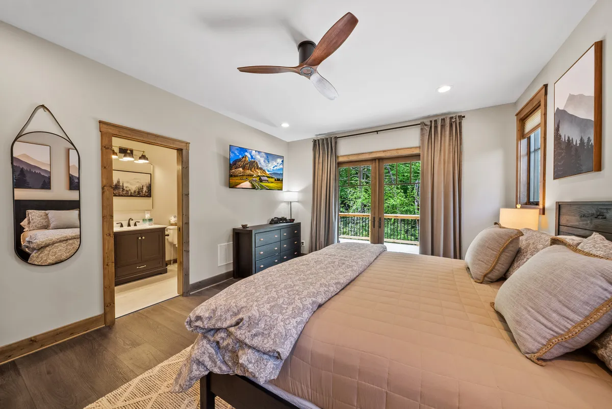A serene bedroom with a comfortable bed positioned to take in stunning views through a large window. The setting is tranquil, perfect for relaxing, reading, or enjoying a morning coffee while soaking in the scenery.